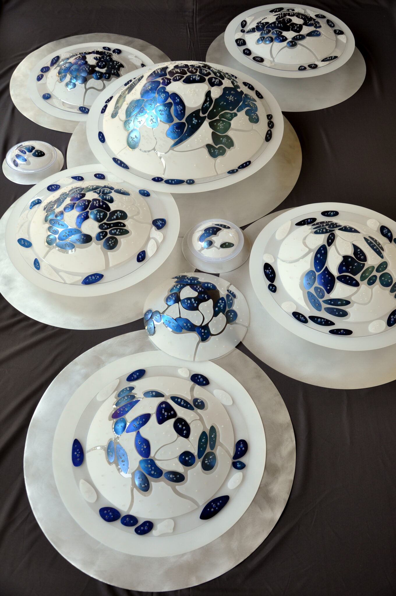 FMcréart – Œuvre Titane Émergence, installation composée de neuf bulles avec titane anodisé aux nuances de bleu